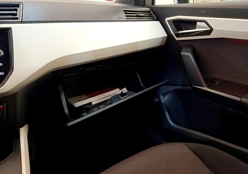 Vue intérieure côté passager du tableau de bord gris clair et boîte à gants ouverte du SEAT Arona 2019.