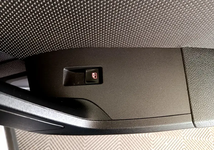 Gros plan sur le bouton d'ouverture du coffre côté conducteur de la SEAT Arona gris clair 2019.