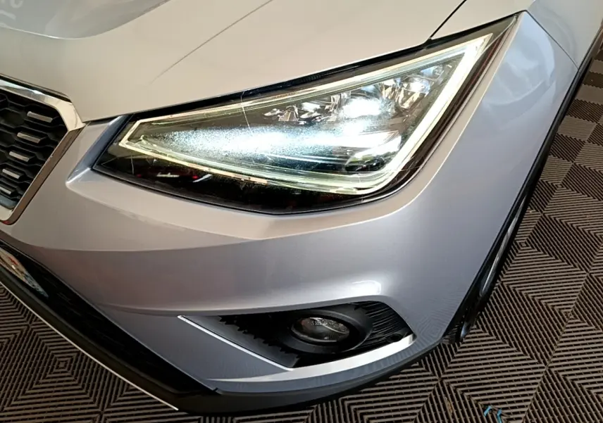 Gros plan sur le phare avant droit gris clair du SEAT Arona 2019 avec antibrouillard et calandre partielle visible.