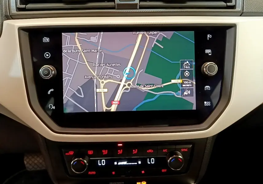 Écran tactile central avec navigation affichée et commandes climatisation digitales dans un SEAT Arona gris clair 2019.