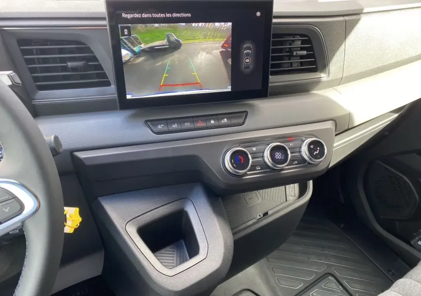 Vue intérieure côté conducteur du tableau de bord gris du Renault Master 2025 avec écran de recul et commandes de climatisation.