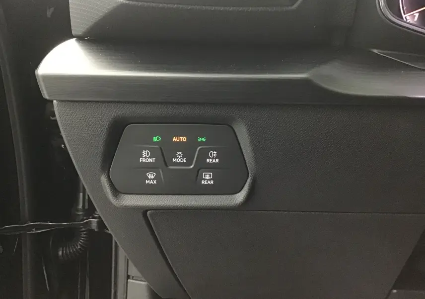 Panneau de commandes d'éclairage avec modes automatiques dans l'habitacle noir d'une CUPRA Leon 2023.