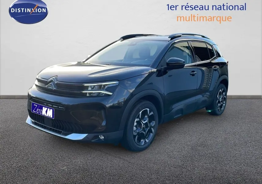 Citroën C5 Aircross noir perla metal en 3/4 avant droit, avec jantes bi-ton et barres de toit visibles.