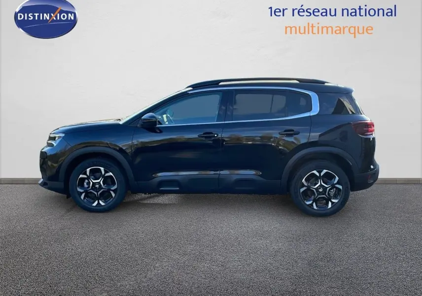 Profil latéral droit d'un Citroën C5 Aircross noir Perla Metal avec jantes bi-ton et barres de toit visibles.