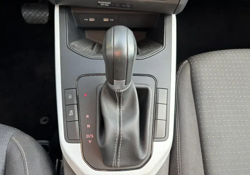 Vue rapprochée du levier de vitesses automatique noir et gris dans l'habitacle du SEAT Arona blanc, version Style TSI 115 DSG.