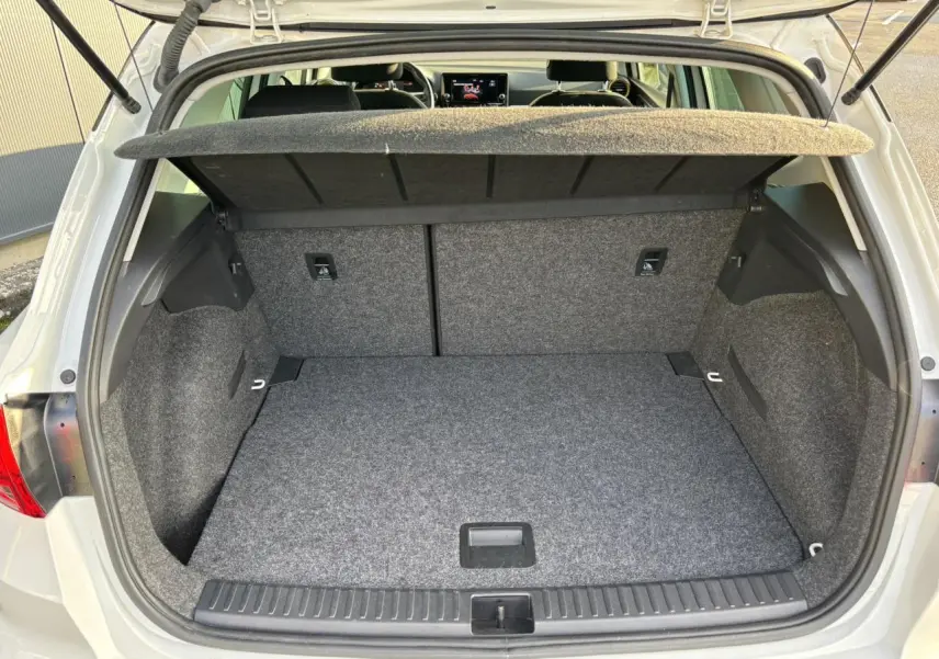 Vue arrière ouverte sur le coffre spacieux et tapissé en gris du SEAT Arona blanc 2025 TSI 115 DSG Style.