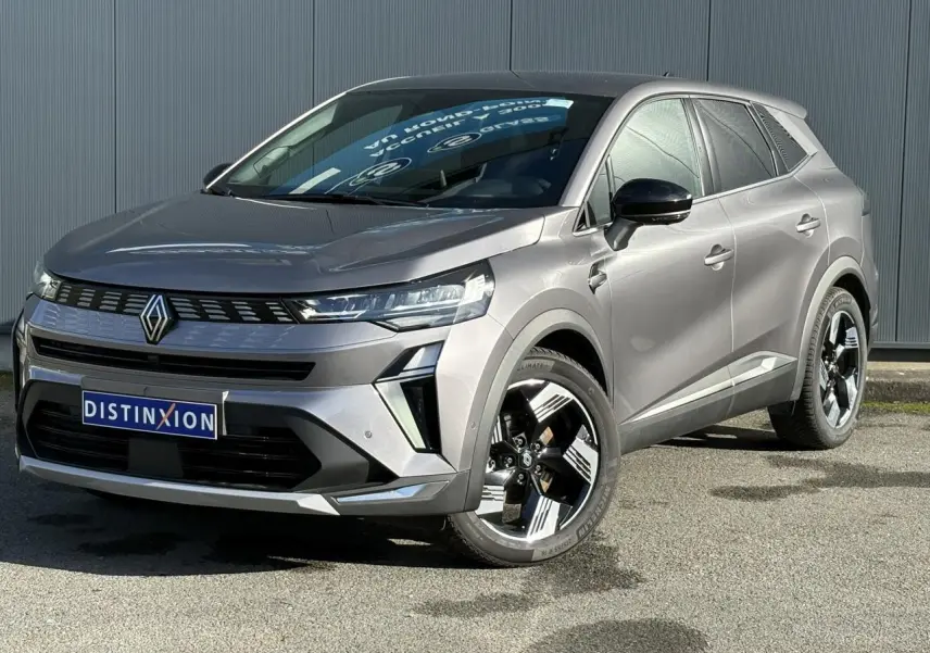 Renault Symbioz E-Tech gris Cassiopée en 3/4 avant droit, avec jantes 18 pouces et calandre moderne.