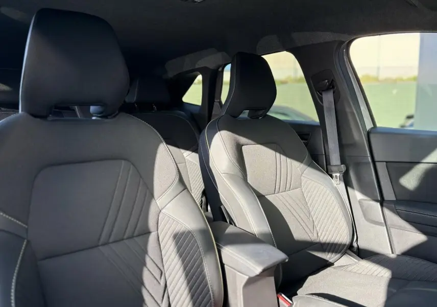 Vue intérieure côté droit montrant les sièges avant gris du Renault SYMBIOZ E-Tech Full Hybrid 2025 avec accoudoir central.