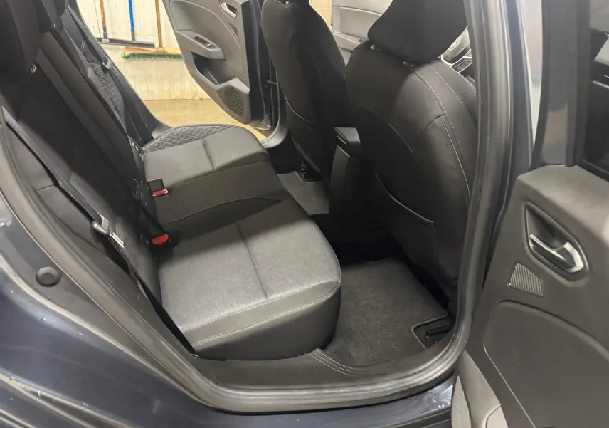 Vue intérieure côté arrière droit de la Renault Clio V Business 2019 gris titanium, montrant les sièges arrière et la porte ouverte.