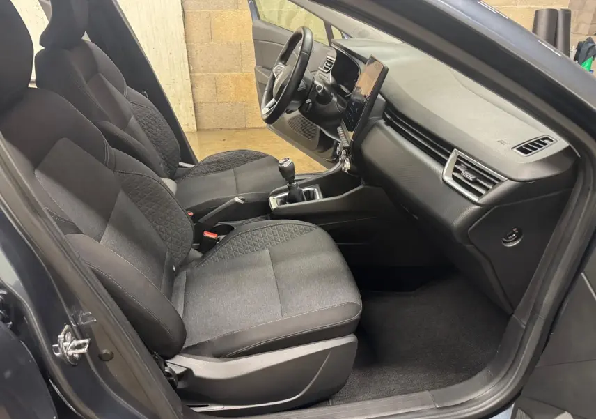 Vue intérieure côté gauche de la Renault Clio V Business 2019, sièges tissu noir et tableau de bord moderne.