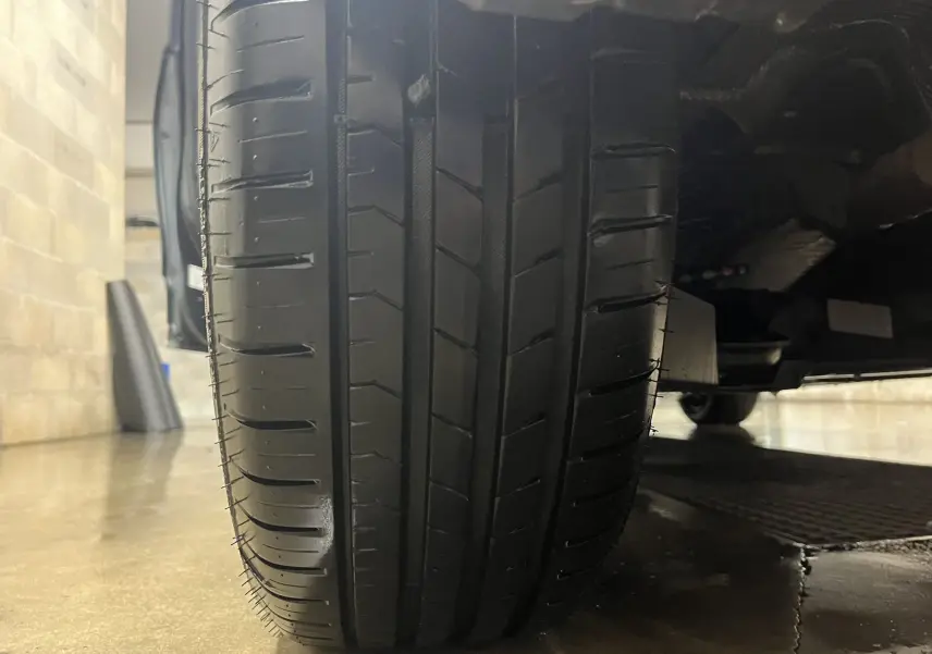 Gros plan sur le pneu avant droit d'une Renault Clio V gris titanium, montrant le profil et la bande de roulement.