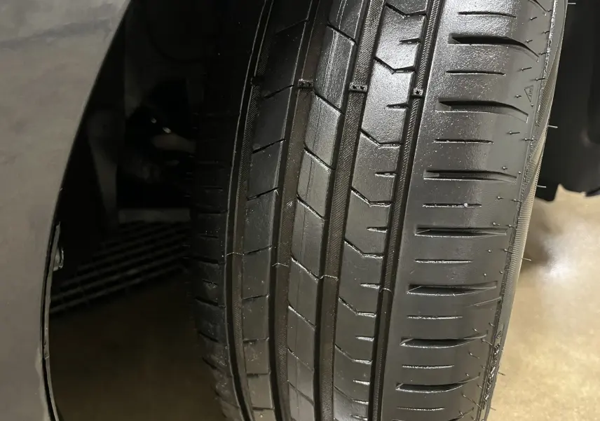 Gros plan sur le pneu avant droit d'une Renault Clio V Business gris Titanium de 2019, montrant la bande de roulement.