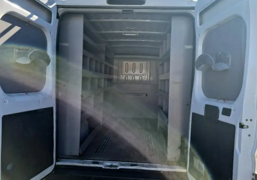 Vue arrière ouverte du Citroën Jumper blanc 2021, montrant l'intérieur aménagé avec étagères de rangement.