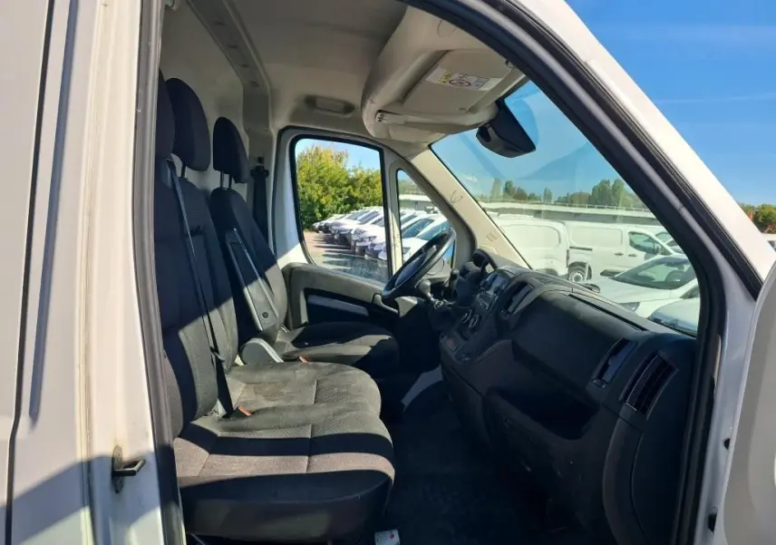 Vue intérieure côté conducteur du Citroën Jumper blanc 2021, montrant les sièges avant et le tableau de bord.