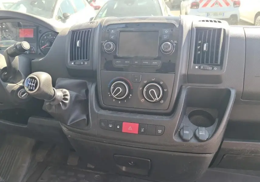 Vue intérieure du tableau de bord du Citroën Jumper blanc 2021, avec levier de vitesse manuel et commandes climatisation visibles.