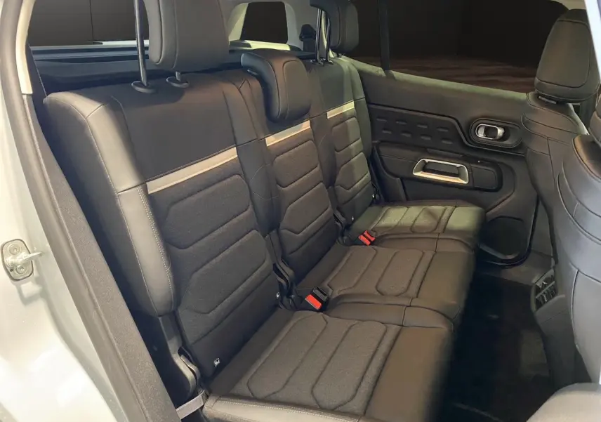 Vue intérieure côté droit des sièges arrière noirs en tissu et cuir du Citroën C5 Aircross 2024 blanc/noir.