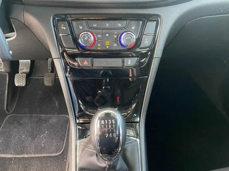 Vue rapprochée du levier de vitesses manuel et de la console centrale noire brillante de l'Opel Mokka 2017.