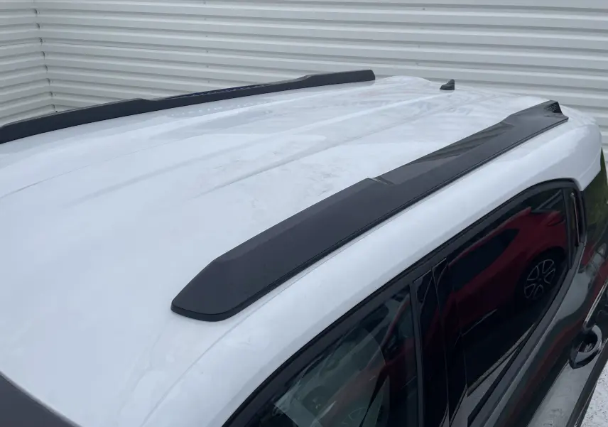 Toit blanc opale avec barres de toit noires sur Citroën C3 Aircross hybride 2026, vue en plongée côté droit.