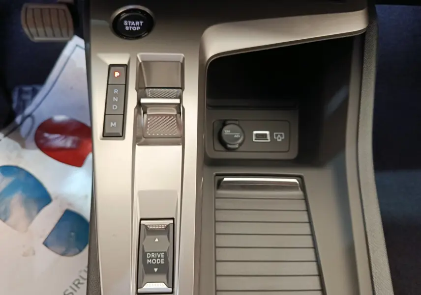 Vue rapprochée de la console centrale de la Peugeot 308 2026, avec sélecteur de boîte auto et prise 12V visible.