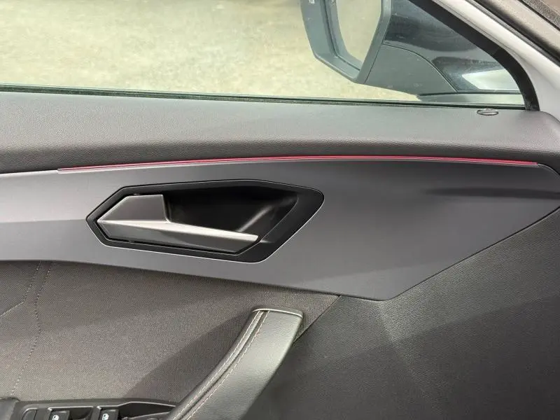 Détail de la porte côté conducteur du CUPRA Formentor 2025 avec poignée noire et bande lumineuse rouge intégrée.