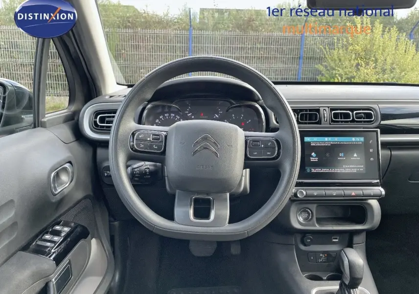 Intérieur de la Citroën C3 2023, vue centrée sur le volant, tableau de bord et écran tactile, ambiance sobre et moderne.
