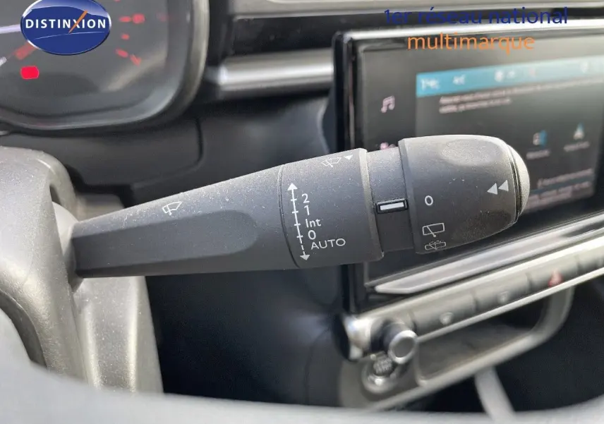 Gros plan sur la commande d'essuie-glace à gauche du volant dans l'habitacle de la Citroën C3 gris platinium 2023.