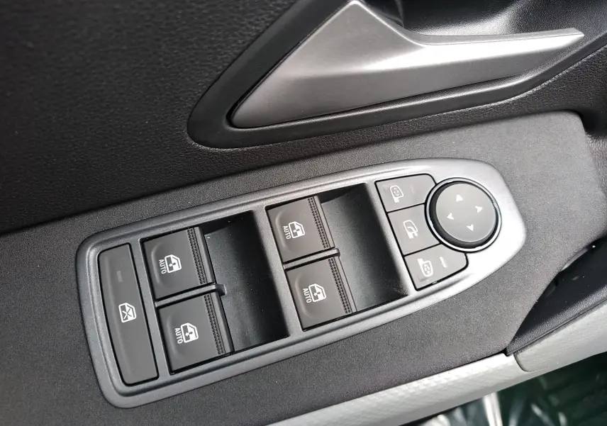 Commandes des vitres électriques et réglage des rétroviseurs sur la porte côté conducteur d'une Dacia Bigster gris schiste 2025.