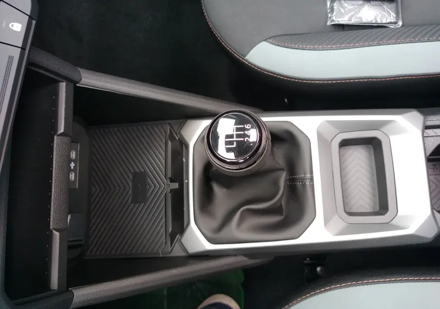 Vue plongeante sur la console centrale grise et noire du Dacia Bigster 2025, mettant en valeur le levier de vitesse manuel.