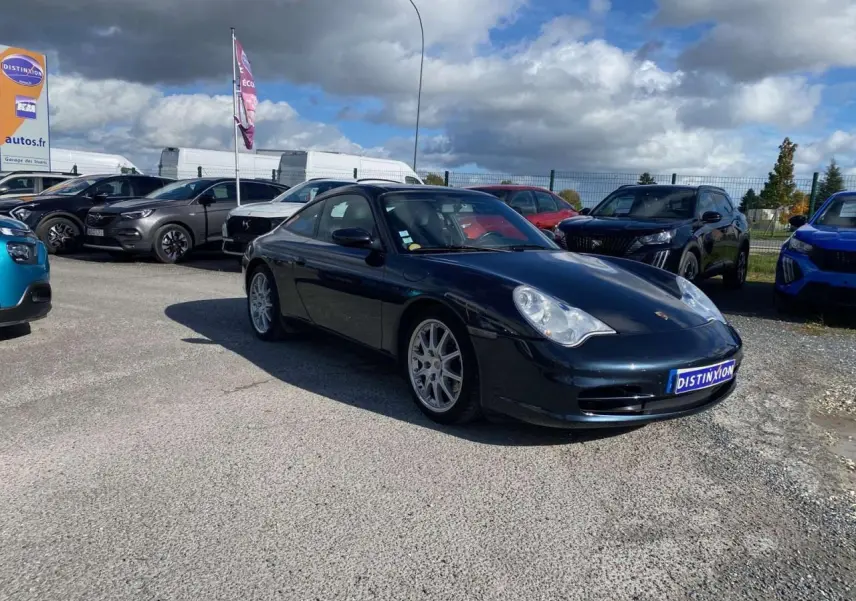 Porsche 911 Targa 3.6i 2004 gris foncé vue 3/4 avant droit sur parking extérieur sous ciel nuageux.
