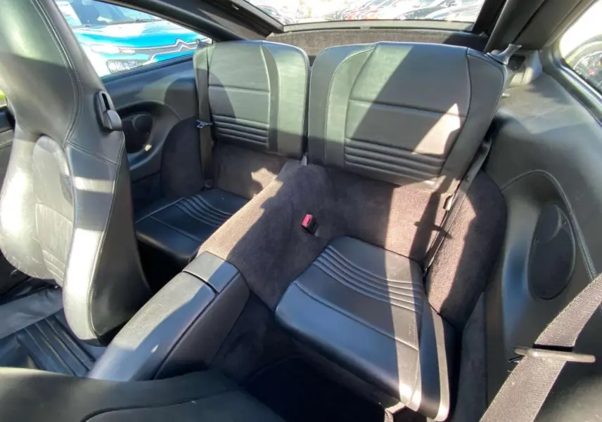 Vue intérieure arrière montrant les sièges en cuir noir de la Porsche 911 Targa 3.6i gris foncé de 2004.