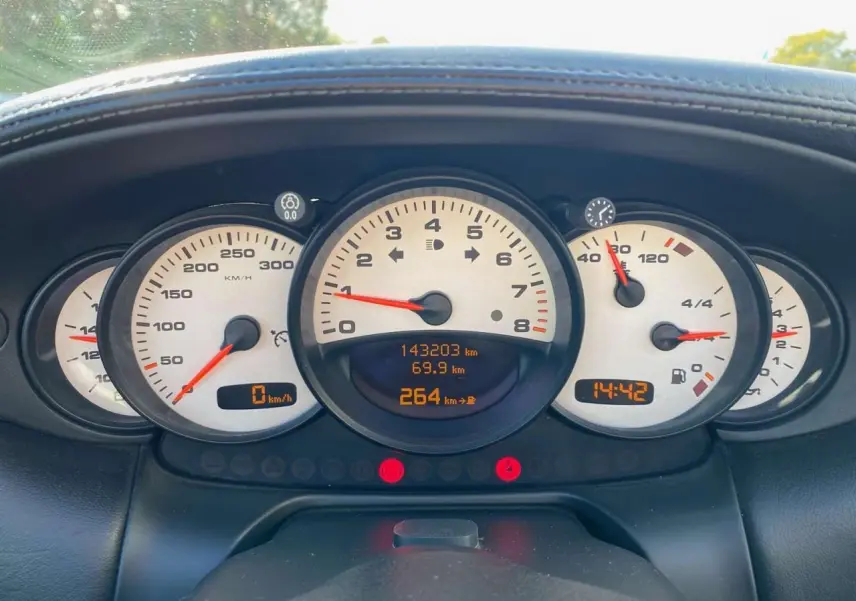 Tableau de bord de Porsche 911 Targa 2004, vue frontale sur compteurs blancs et affichage numérique orange.