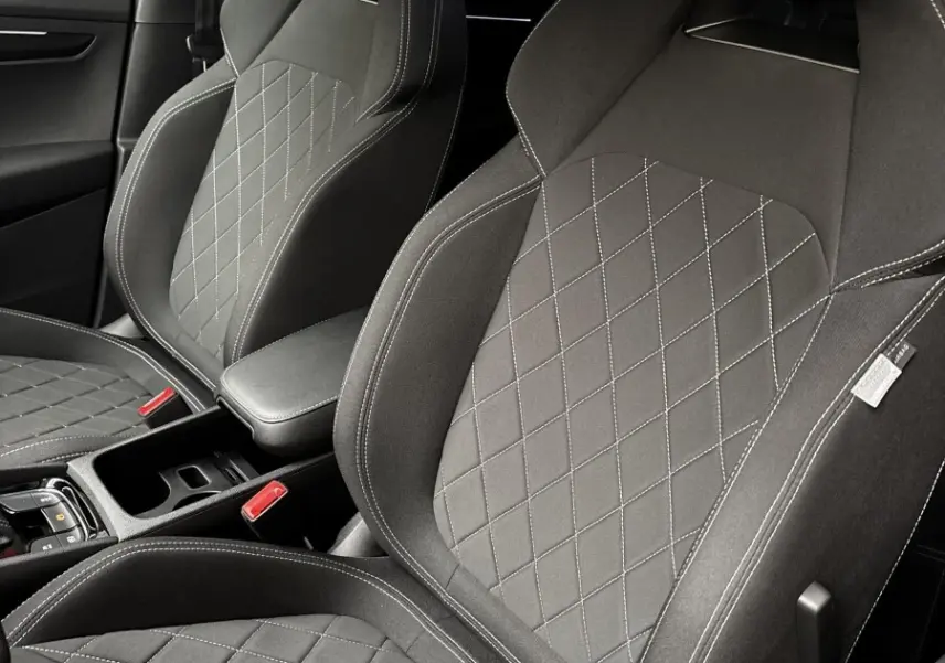 Gros plan sur les sièges avant noirs au tissu matelassé du Skoda Karoq 2025 version Sportline.