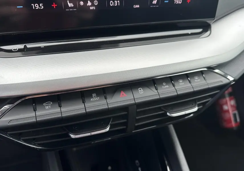 Gros plan sur la console centrale de la Skoda Octavia Combi 2024, montrant les commandes de climatisation et d'assistance.