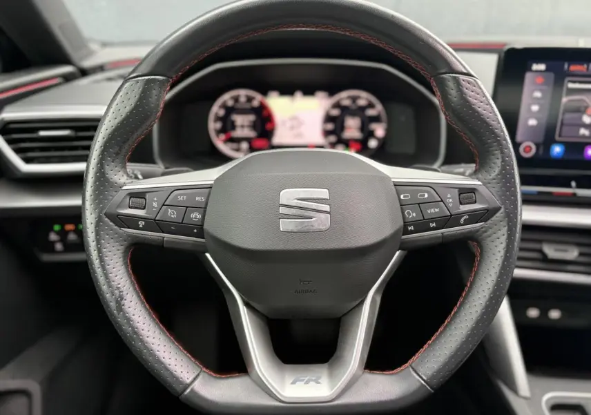 Volant cuir perforé avec surpiqûres rouges et logo FR du SEAT LEON 1.5 e-TSI 150 DSG7 vue de face intérieure