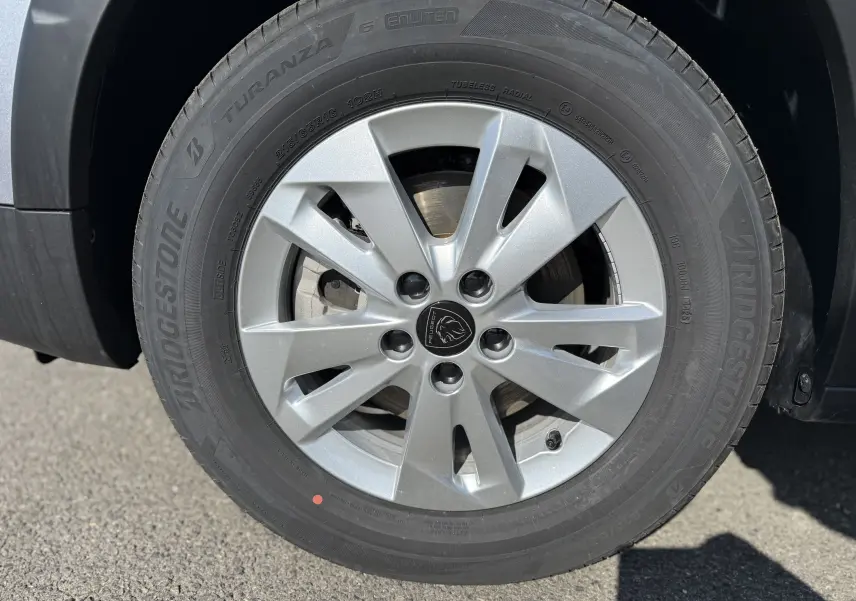 Gros plan sur les commandes de lève-vitres et réglage des rétroviseurs côté conducteur du Peugeot Rifter gris acier.