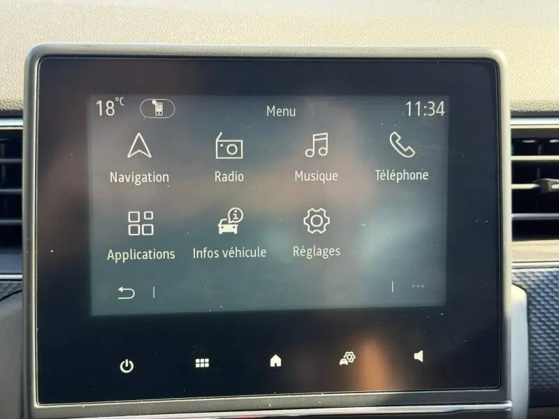 Écran tactile central du Renault Arkana 2025 affichant le menu principal avec navigation, radio et réglages.