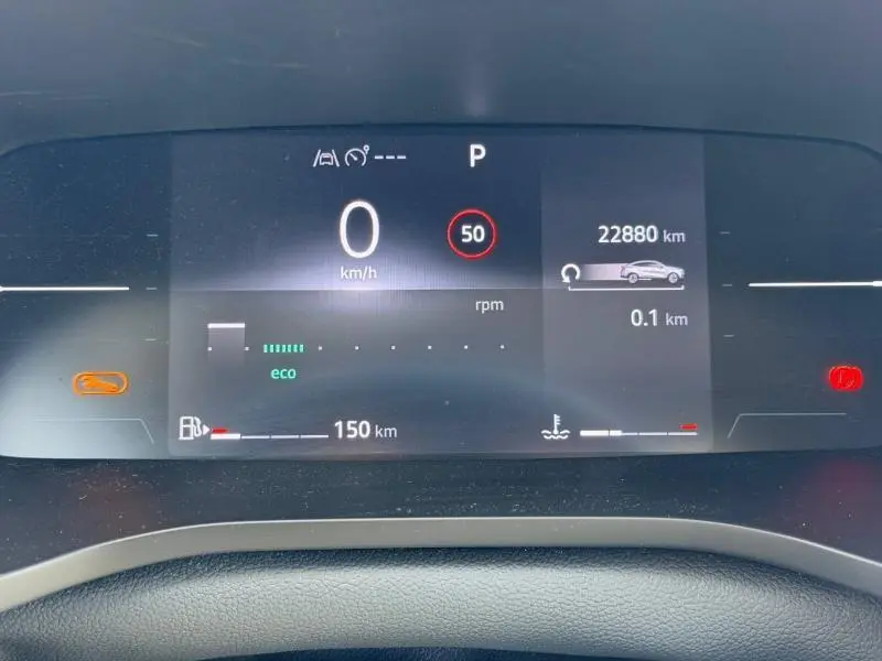 Tableau de bord numérique du Renault Arkana 2025 affichant vitesse, autonomie et indicateurs, vue frontale intérieure.