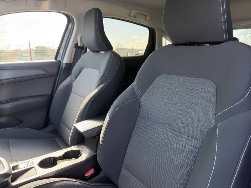 Vue intérieure rapprochée des sièges avant en tissu gris avec surpiqûres blanches du Renault Arkana 2025.