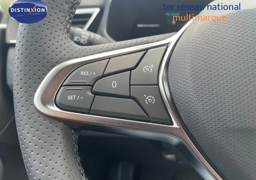 Gros plan sur les commandes de régulateur de vitesse au volant perforé d'une Renault Clio TCE 90CH TECHNO 2025.