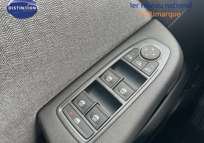 Gros plan sur les commandes des vitres électriques et rétroviseurs côté conducteur d'une Renault Clio TCE 90CH TECHNO bleu Iron Metal.