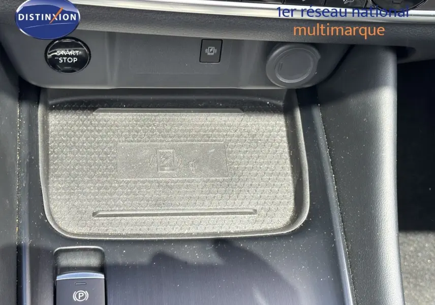 Gros plan sur la console centrale du Nissan Qashqai noir 2024, avec bouton start/stop et zone de charge sans fil.