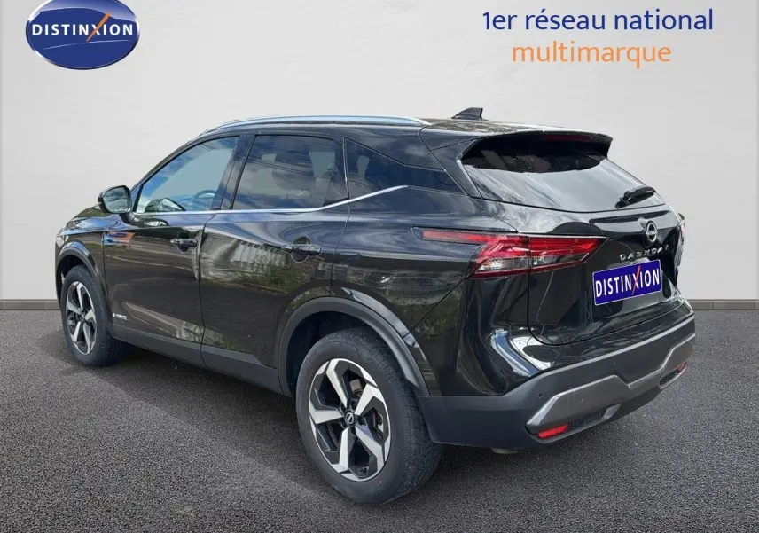 Nissan Qashqai noir 2024 vu 3/4 arrière côté gauche, avec jantes bi-ton et feux arrière LED distinctifs.