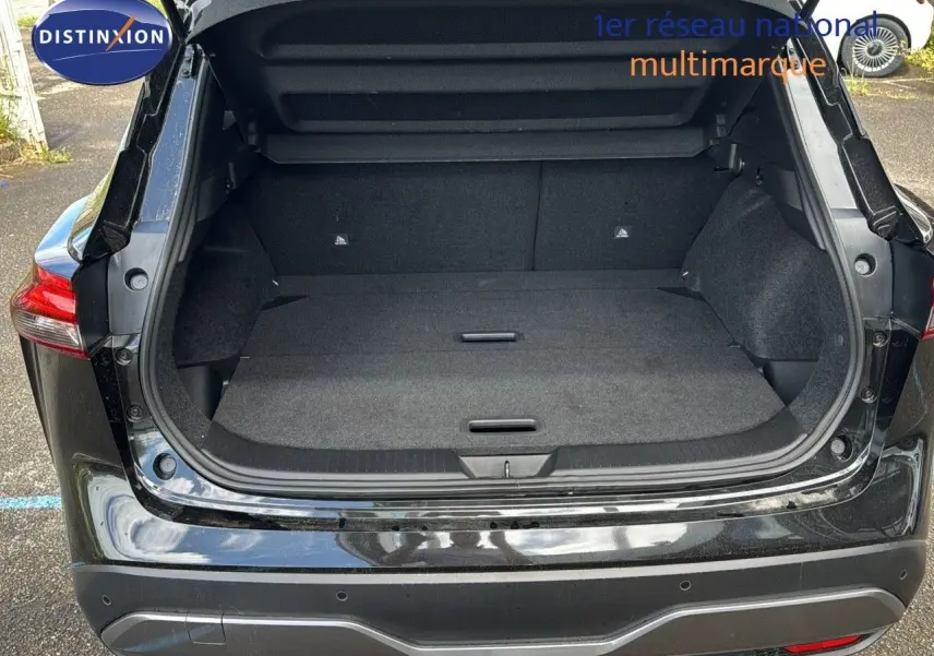 Coffre ouvert en vue arrière d'un Nissan Qashqai noir 2024, montrant un espace de chargement spacieux et propre.