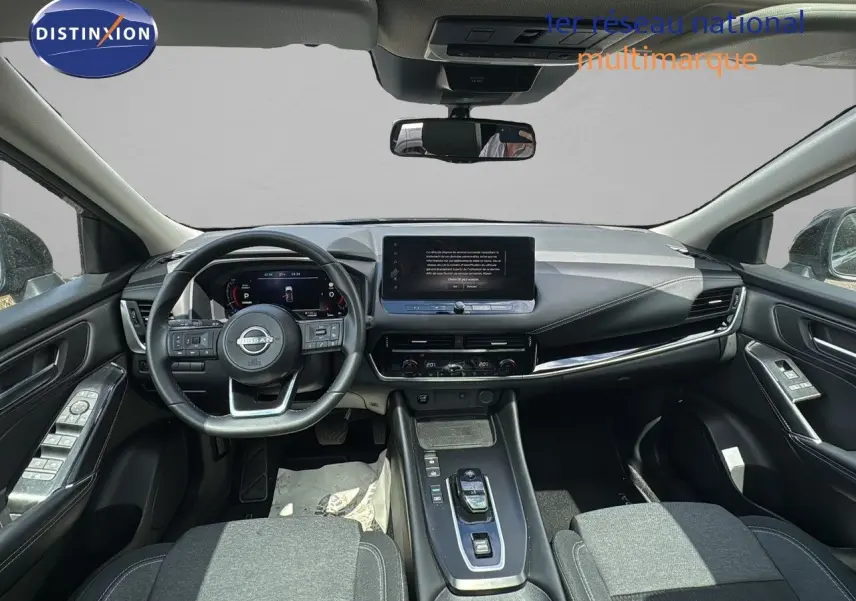 Vue intérieure avant du Nissan Qashqai 1.5 e-Power 2024, tableau de bord moderne avec écran tactile central et volant multifonction noir.