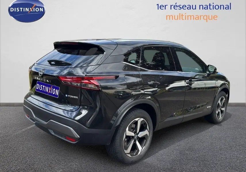 Nissan Qashqai noir en 3/4 arrière côté gauche, mettant en valeur ses feux effilés et jantes bi-ton modernes.