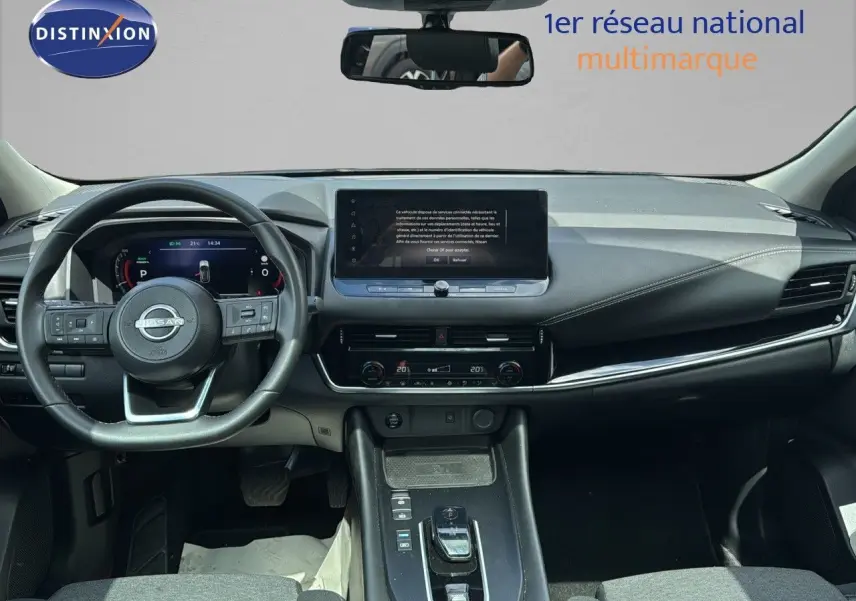 Vue frontale de l'intérieur du Nissan Qashqai 2024 noir, avec tableau de bord numérique et écran tactile central.