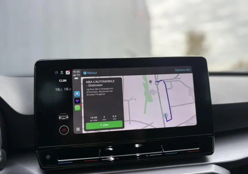 Écran tactile 10 pouces du système de navigation SEAT Leon 2024 affichant un itinéraire et la climatisation à 18°C.