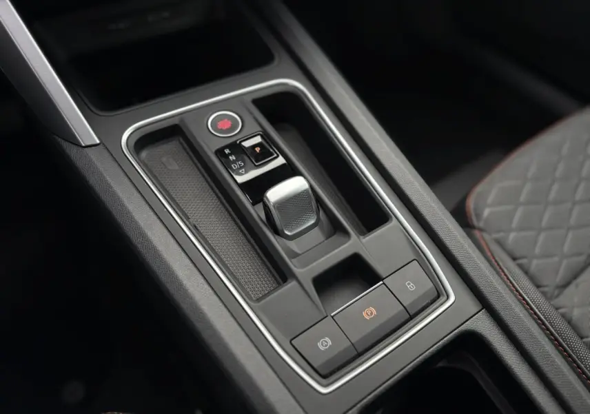 Gros plan sur la console centrale noire avec levier de boîte automatique de la SEAT LEON 1.5 e-TSI 150 DSG7 FR.