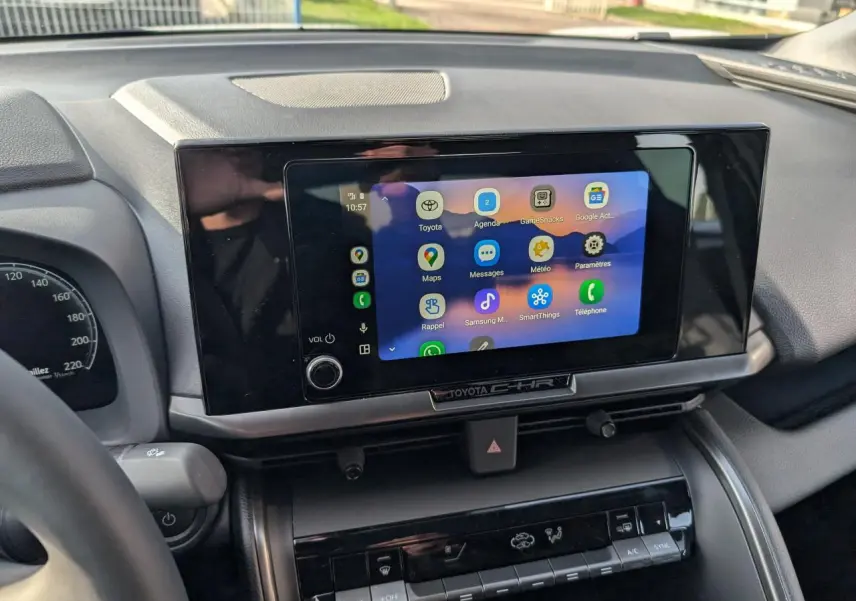 Vue rapprochée de l’écran tactile central du Toyota C-HR 2024 avec interface connectée et tableau de bord noir.