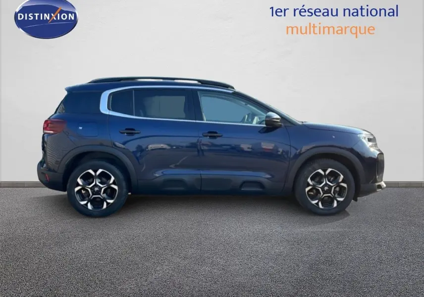 Profil droit d'un Citroën C5 Aircross 2025 bleu Eclipse Métal avec jantes bi-ton et barres de toit noires.